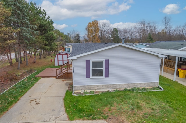 view of side of property featuring a storage unit and a yard