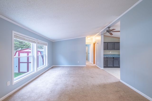 unfurnished living room with light carpet, crown molding, vaulted ceiling, ceiling fan, and a textured ceiling