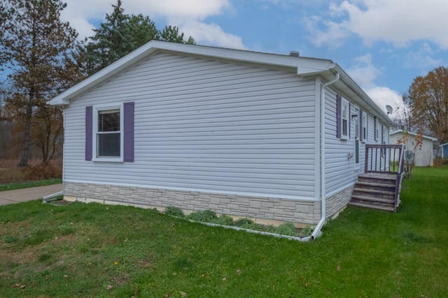 view of side of home with a yard