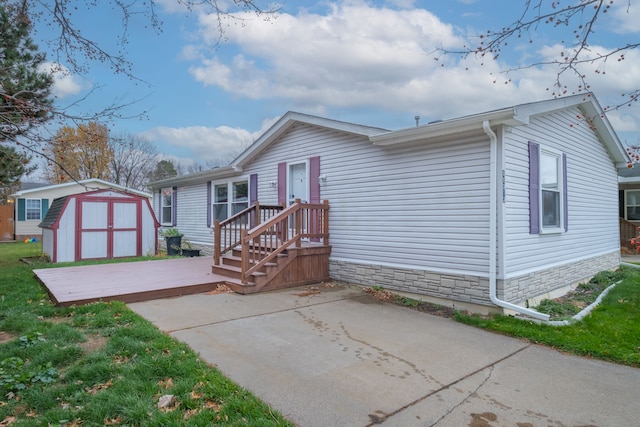 exterior space with a patio, a storage unit, and a wooden deck