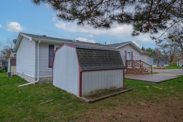 view of outbuilding with central air condition unit and a yard