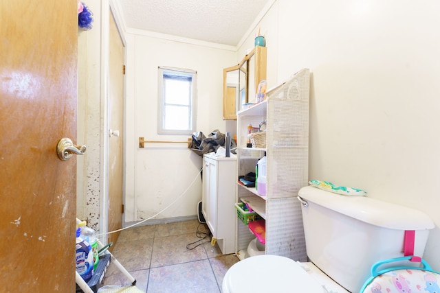 bathroom featuring tile patterned flooring, ornamental molding, a textured ceiling, and toilet