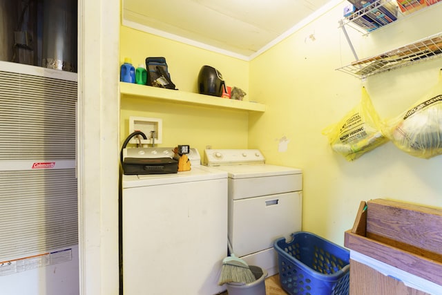 laundry room with washing machine and clothes dryer and ornamental molding