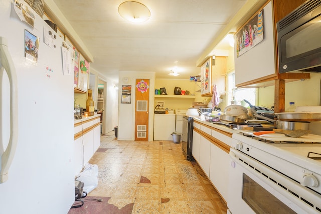 kitchen with white cabinets, white appliances, and separate washer and dryer