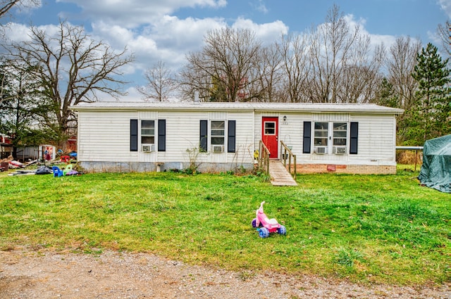 manufactured / mobile home with cooling unit and a front lawn