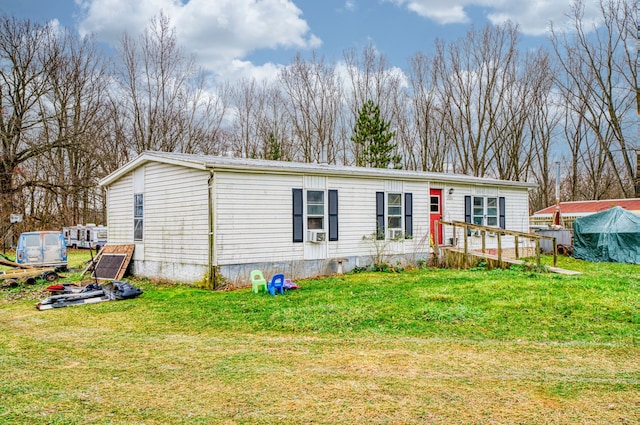 rear view of property with a lawn, a wooden deck, and cooling unit