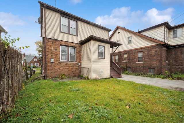 rear view of house featuring a lawn