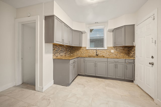 kitchen with gray cabinets, sink, and tasteful backsplash