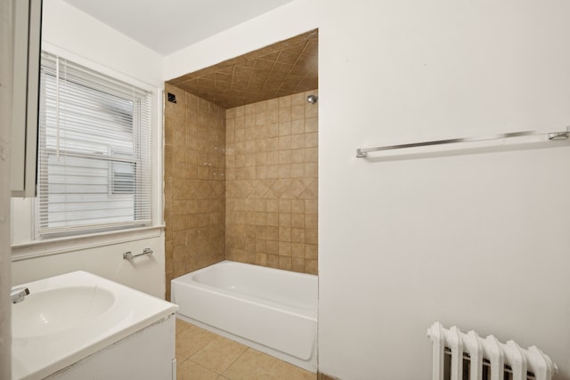 bathroom featuring tile patterned floors, vanity, tiled shower / bath, and radiator