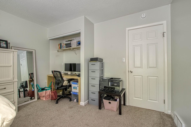 office featuring light colored carpet and a textured ceiling