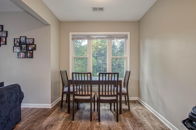 dining space featuring dark hardwood / wood-style floors and a textured ceiling