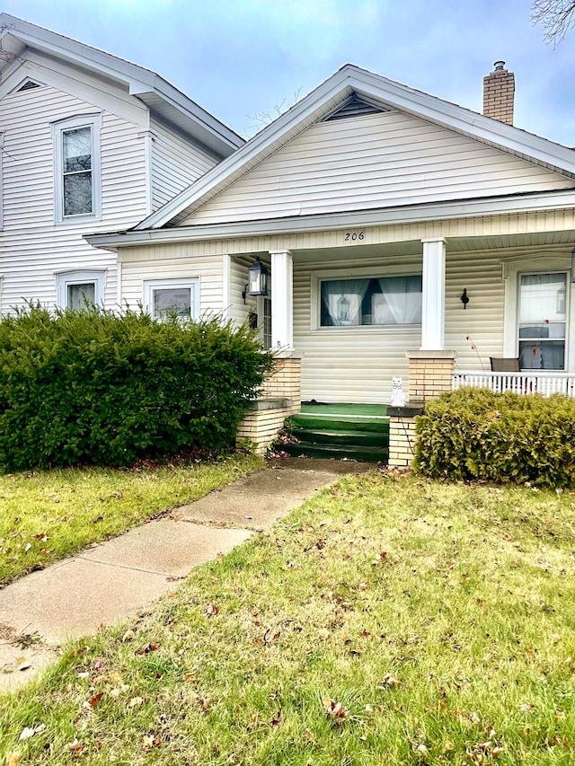 view of front of house with covered porch and a front yard