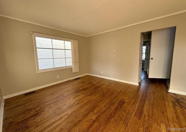 spare room featuring dark hardwood / wood-style floors and ornamental molding