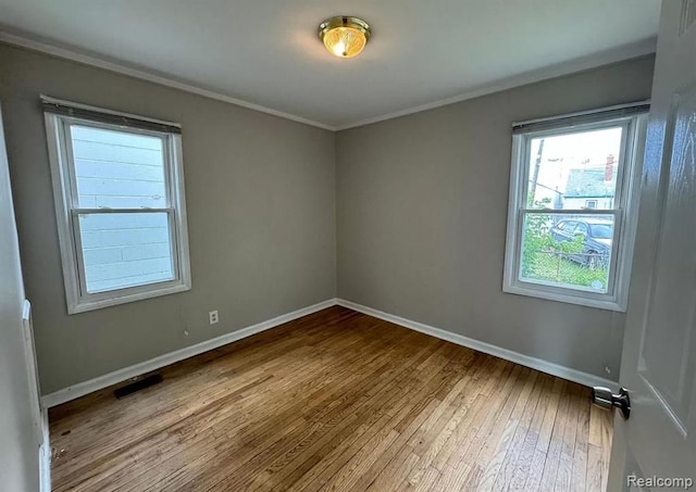 spare room featuring hardwood / wood-style flooring and crown molding