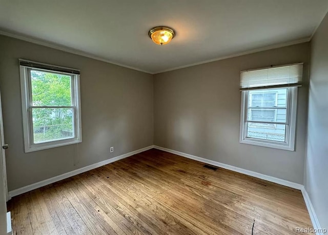 empty room featuring hardwood / wood-style floors and crown molding