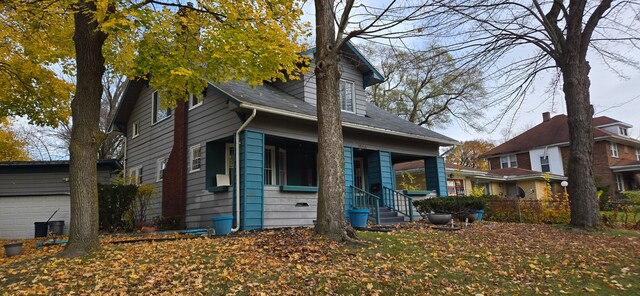 view of front of house with a garage and an outbuilding