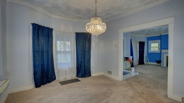 carpeted spare room with visible vents, baseboards, ornamental molding, and a chandelier