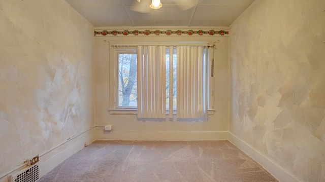 spare room featuring carpet, visible vents, and baseboards