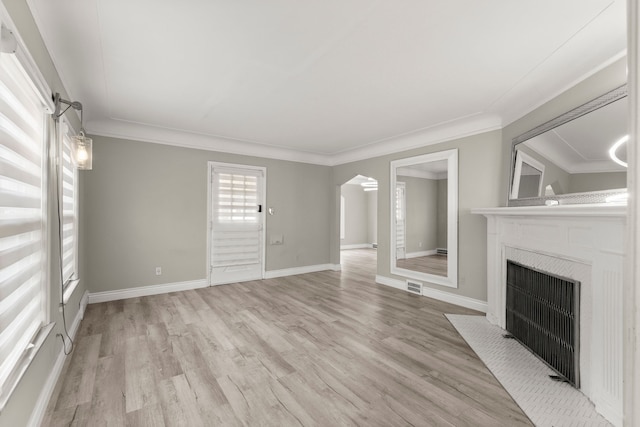 unfurnished living room featuring crown molding and light wood-type flooring