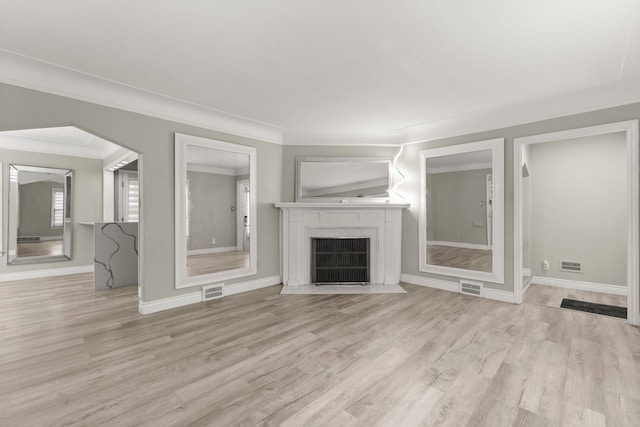 unfurnished living room with light hardwood / wood-style floors and crown molding