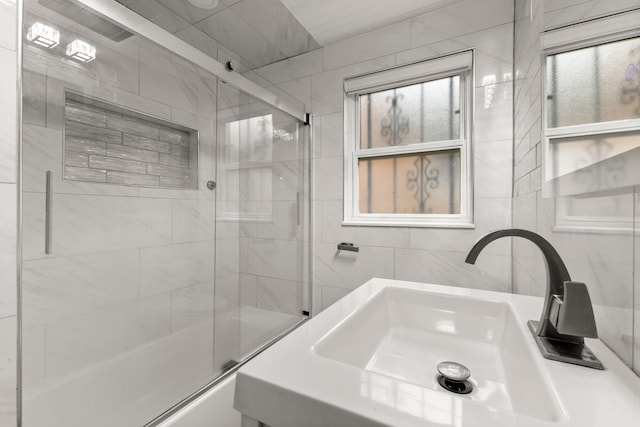 bathroom with enclosed tub / shower combo and sink