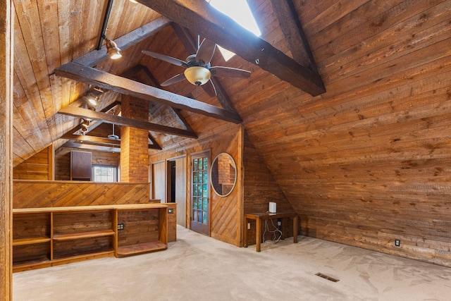 additional living space with carpet, lofted ceiling with beams, and wood walls