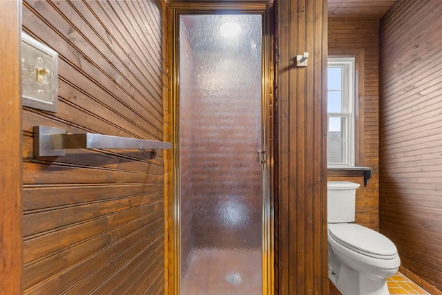 bathroom with wood walls and toilet