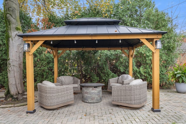 view of patio featuring a gazebo and an outdoor living space with a fire pit