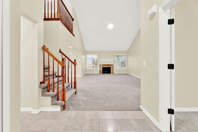 interior space with a tile fireplace and high vaulted ceiling