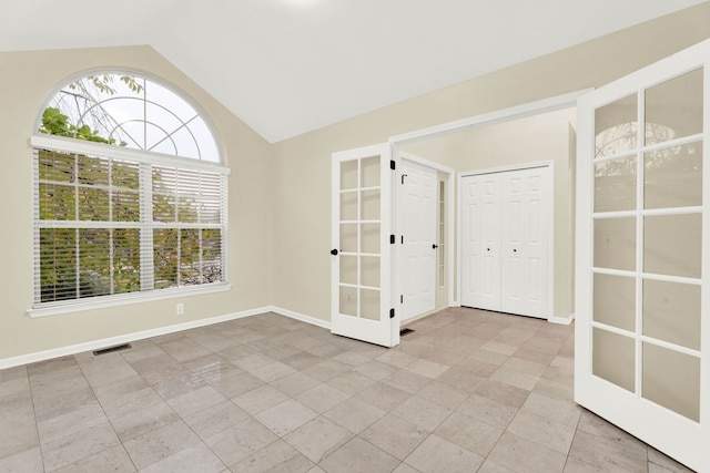 unfurnished room featuring french doors and lofted ceiling