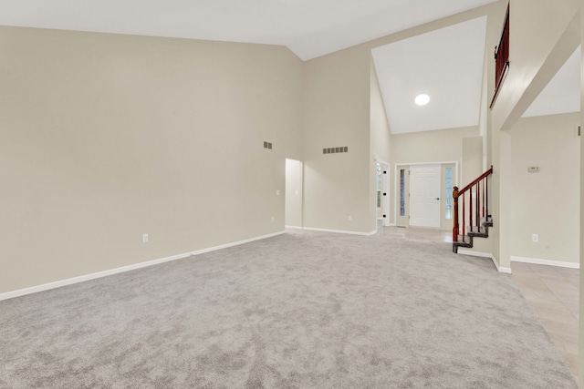 unfurnished living room with light colored carpet and high vaulted ceiling