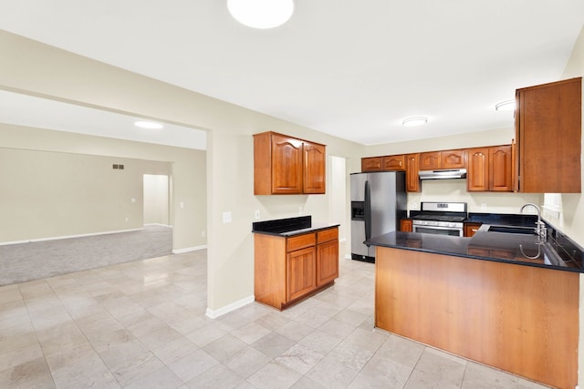 kitchen with kitchen peninsula, appliances with stainless steel finishes, light colored carpet, and sink