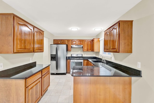 kitchen featuring dark stone counters, sink, light tile patterned flooring, kitchen peninsula, and stainless steel appliances