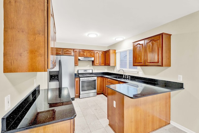 kitchen featuring sink, stainless steel appliances, kitchen peninsula, dark stone countertops, and light tile patterned flooring