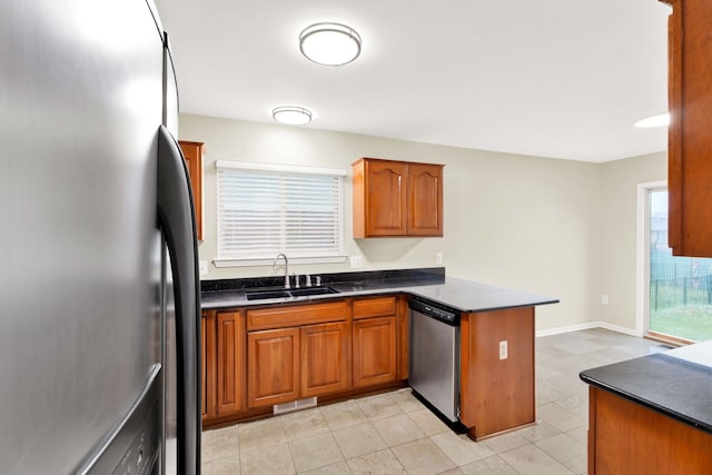 kitchen with kitchen peninsula, a wealth of natural light, sink, and stainless steel appliances