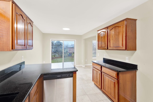 kitchen with kitchen peninsula, sink, stainless steel dishwasher, and dark stone countertops