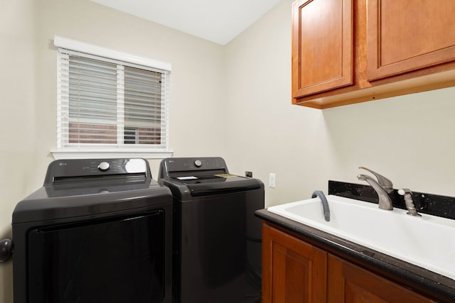 washroom with cabinets, washer and clothes dryer, and sink