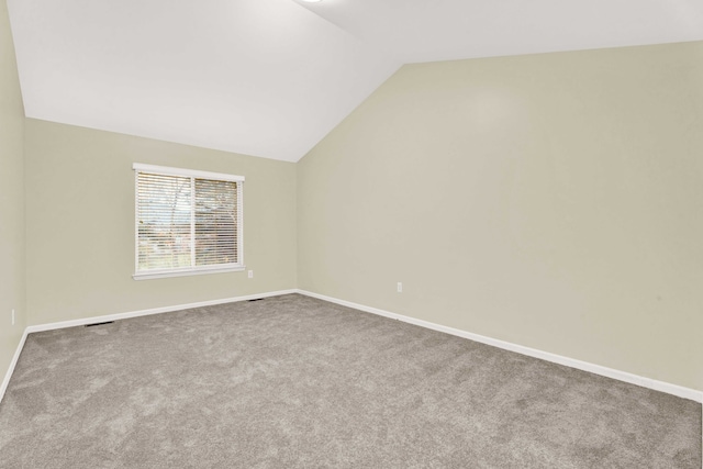 additional living space with carpet floors and vaulted ceiling