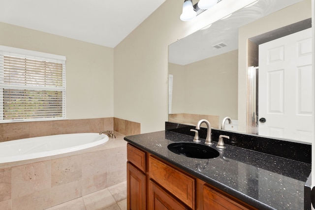 bathroom featuring tiled tub, tile patterned flooring, vanity, and vaulted ceiling