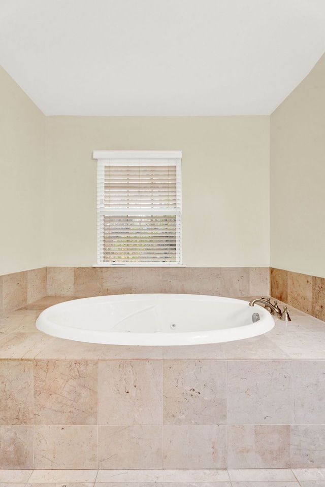 bathroom featuring tile patterned floors and a relaxing tiled tub