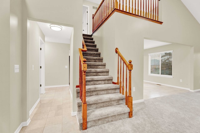 staircase with carpet and a high ceiling