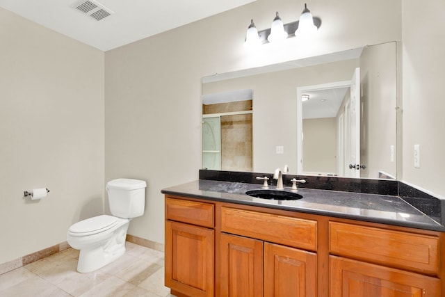 bathroom featuring tile patterned flooring, vanity, toilet, and a shower with door