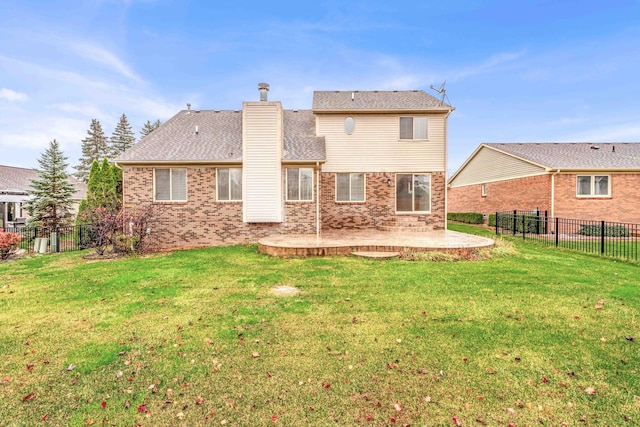 back of house featuring a lawn and a patio area