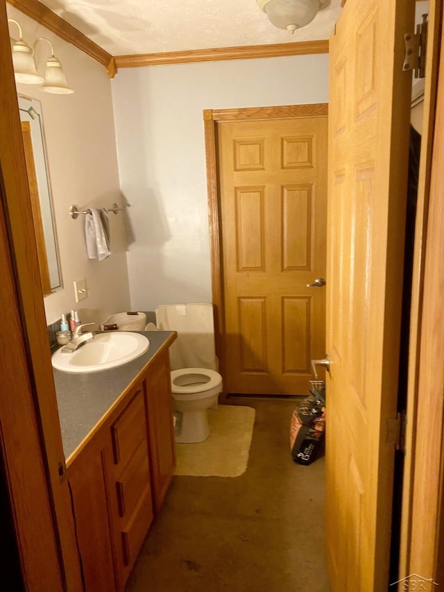 bathroom with vanity, toilet, and ornamental molding