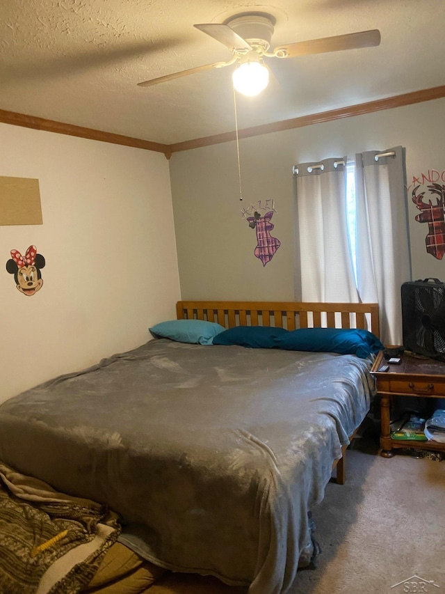 carpeted bedroom with a textured ceiling, ceiling fan, and crown molding