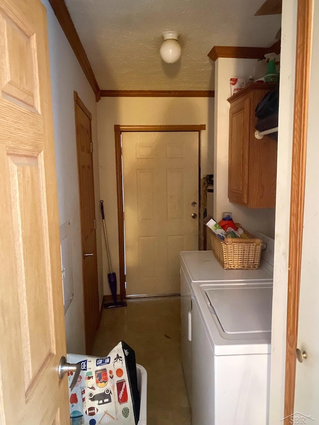 clothes washing area featuring washing machine and clothes dryer, tile patterned flooring, cabinets, and ornamental molding