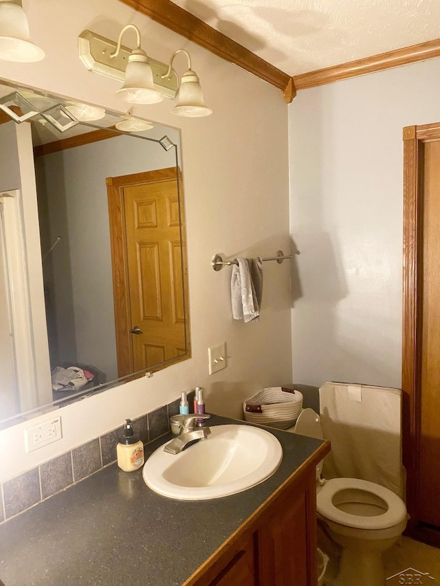 bathroom with vanity, toilet, and ornamental molding