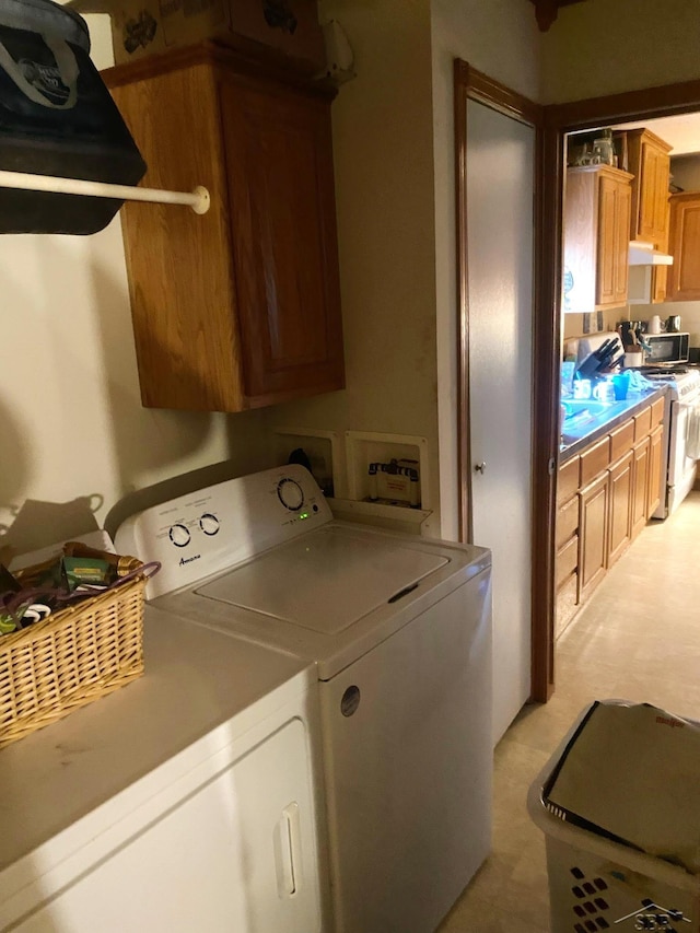 laundry room with washer and dryer and cabinets