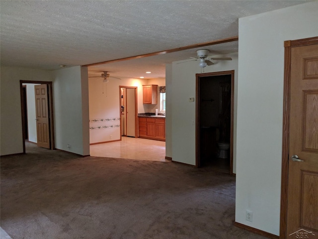 carpeted empty room featuring ceiling fan and a textured ceiling