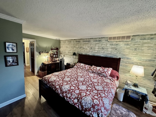 bedroom with a textured ceiling, wood-type flooring, and ornamental molding